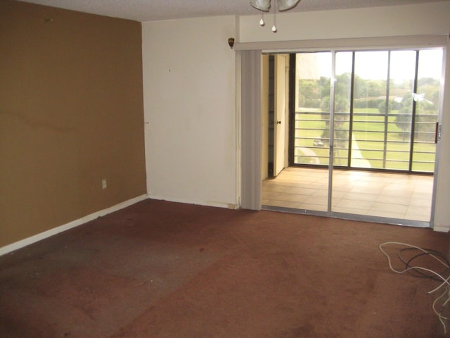 spare room featuring carpet flooring and baseboards