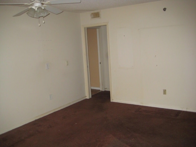 spare room featuring visible vents, baseboards, a textured ceiling, and ceiling fan