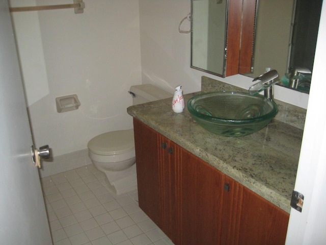 half bathroom with tile patterned flooring, toilet, and vanity