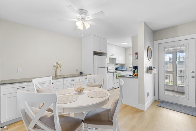 dining room with a ceiling fan, a toaster, light wood-style flooring, and baseboards