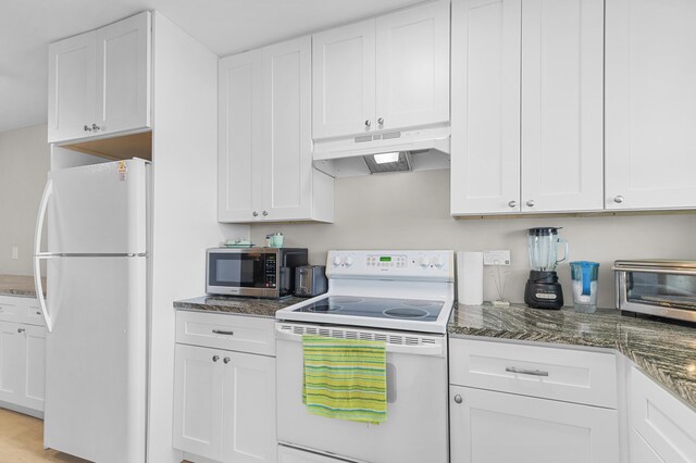 kitchen with dark stone counters, white appliances, white cabinets, and under cabinet range hood