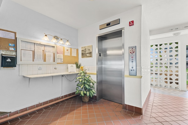 kitchen featuring elevator, light countertops, and tile patterned floors