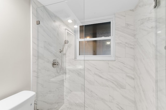 bathroom featuring a stall shower and toilet