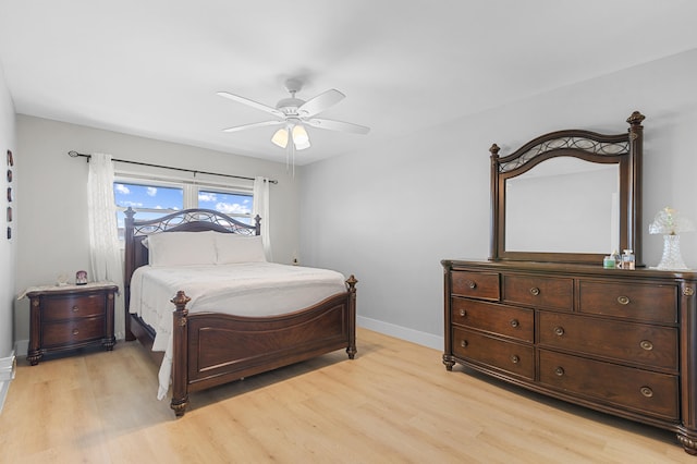 bedroom with ceiling fan, light wood-style flooring, and baseboards