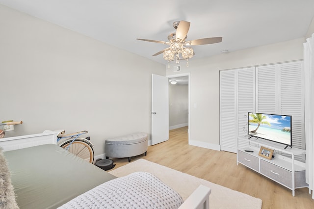 bedroom with light wood-style floors, a closet, ceiling fan, and baseboards