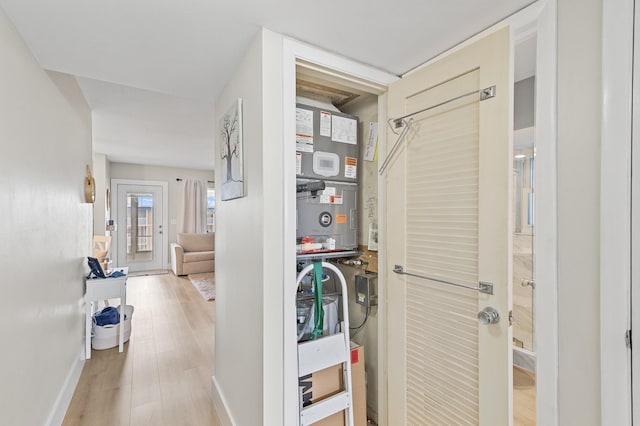 corridor with baseboards and wood finished floors