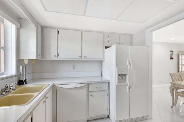 kitchen with light countertops, white appliances, and a sink