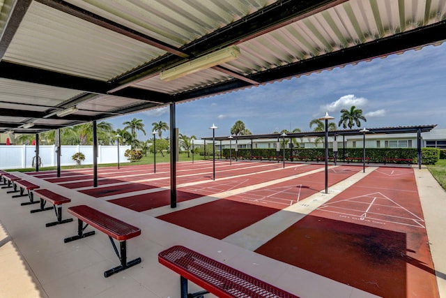 view of community featuring shuffleboard and fence