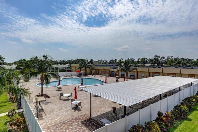 community pool with a patio area and a fenced backyard