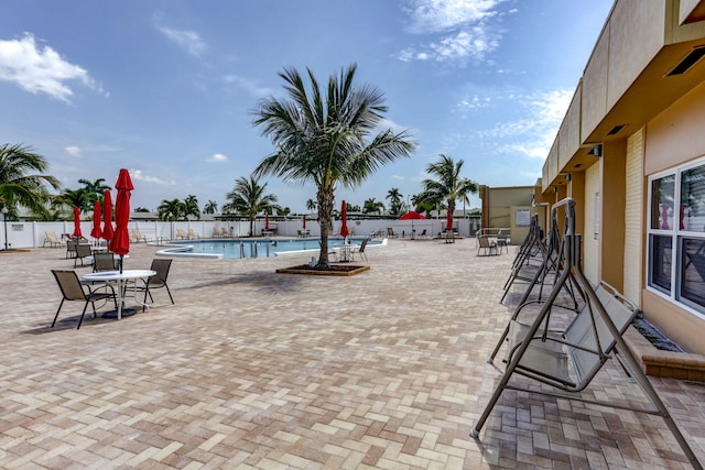 community pool with fence and a patio