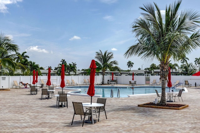 community pool featuring a patio and fence