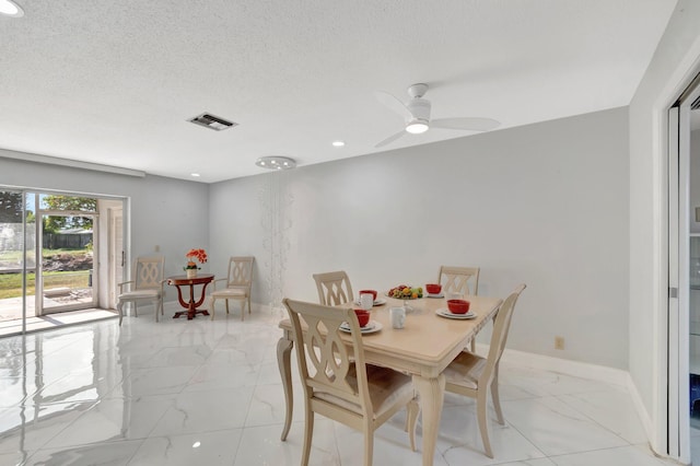 dining space featuring marble finish floor, baseboards, visible vents, and a textured ceiling