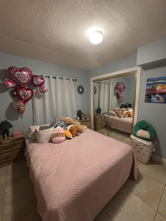 bedroom with tile patterned flooring, a closet, and a textured ceiling