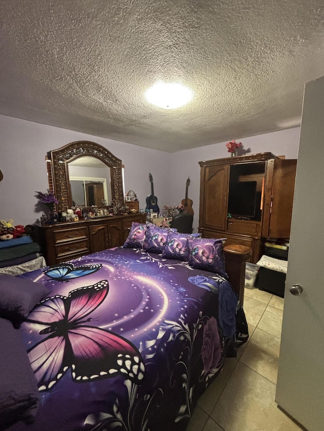 bedroom with a textured ceiling and light tile patterned flooring