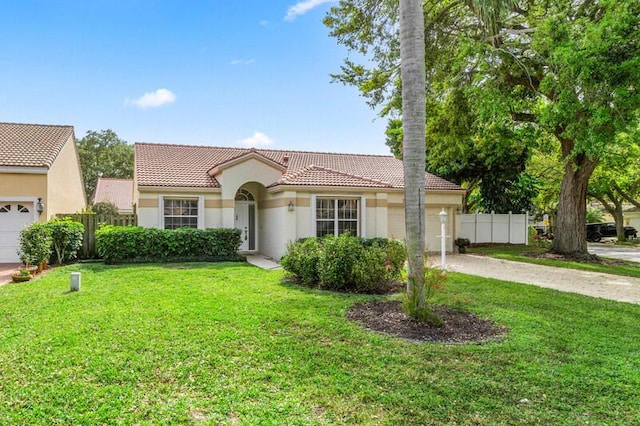 mediterranean / spanish-style home with stucco siding, fence, concrete driveway, a front yard, and a tiled roof