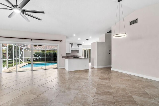 unfurnished living room with a ceiling fan, light tile patterned flooring, baseboards, and visible vents