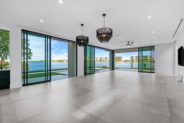 spare room with a water view, baseboards, floor to ceiling windows, and recessed lighting