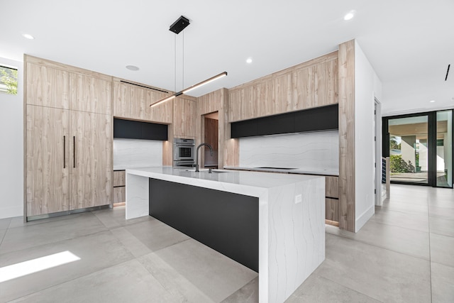 kitchen featuring concrete flooring, light brown cabinetry, and modern cabinets