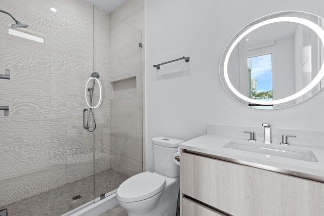 bathroom featuring toilet, a tile shower, and vanity