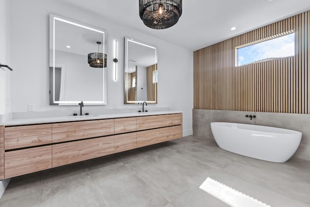 bathroom featuring a freestanding tub, a sink, and double vanity