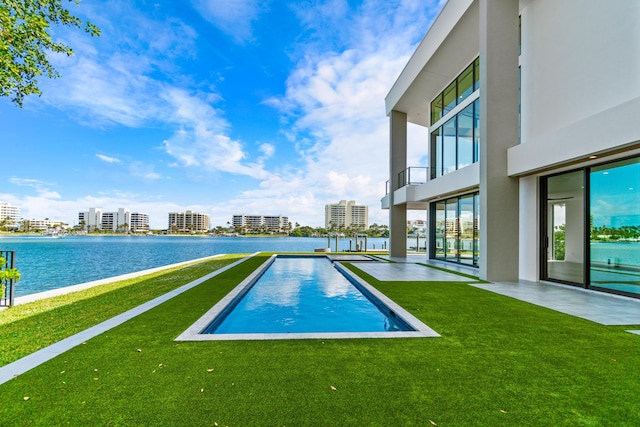 outdoor pool with a water view, a city view, and a lawn