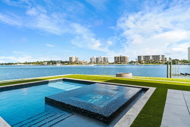 view of swimming pool with a view of city, a lawn, and a hot tub