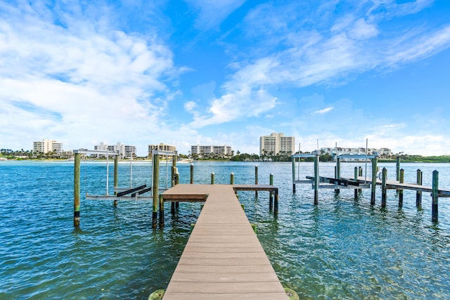 view of dock with a city view, a water view, and boat lift