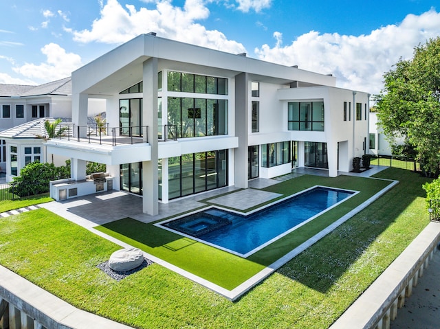 rear view of house with a yard, a balcony, area for grilling, and a patio