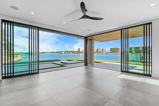 interior space featuring a ceiling fan, floor to ceiling windows, and a water view