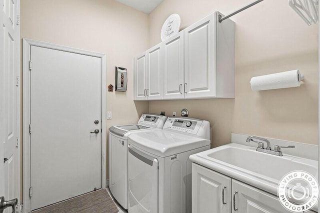 clothes washing area featuring cabinet space, independent washer and dryer, and a sink