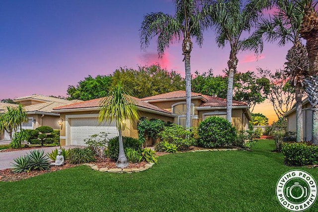 view of front of home featuring stucco siding, a garage, a front yard, and a tiled roof