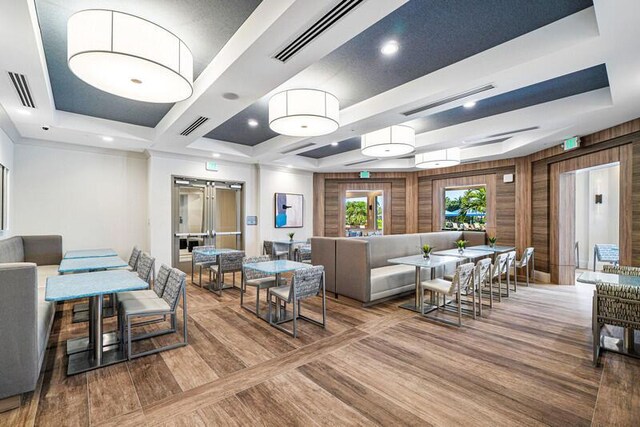 living area with a tray ceiling and visible vents