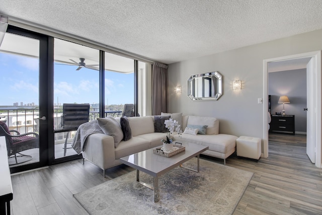 336 Golfview Rd Unit 807, North Palm Beach, FL 33408 - living area with expansive windows, baseboards, a textured ceiling, and wood finished floors