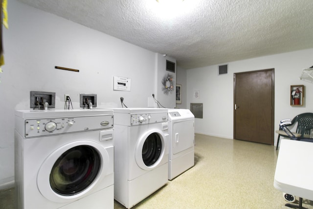 laundry room featuring visible vents, a textured ceiling, and separate washer and dryer