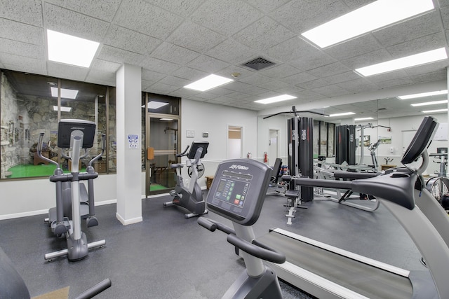 workout area with baseboards, a paneled ceiling, and visible vents