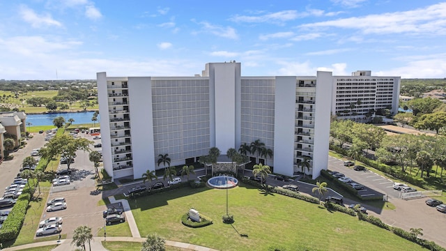 view of building exterior with a water view and uncovered parking