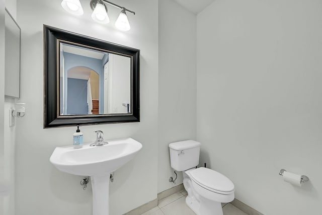 bathroom featuring tile patterned flooring, baseboards, and toilet