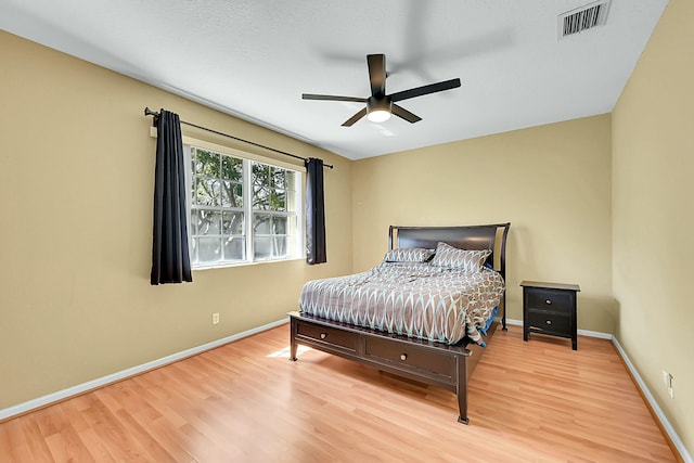 bedroom with visible vents, baseboards, ceiling fan, and wood finished floors