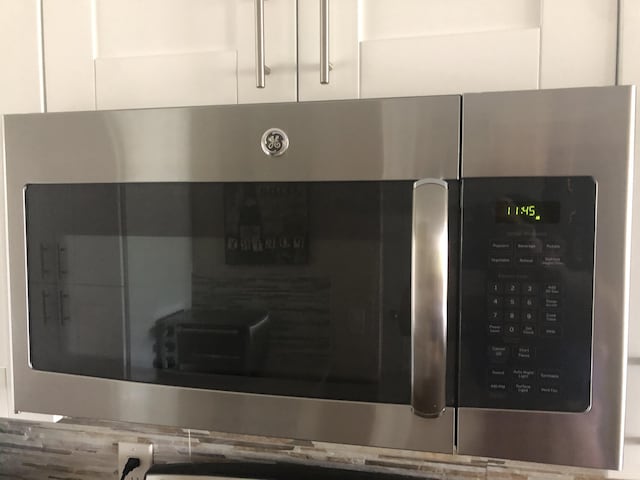 interior details featuring white cabinetry and stainless steel microwave