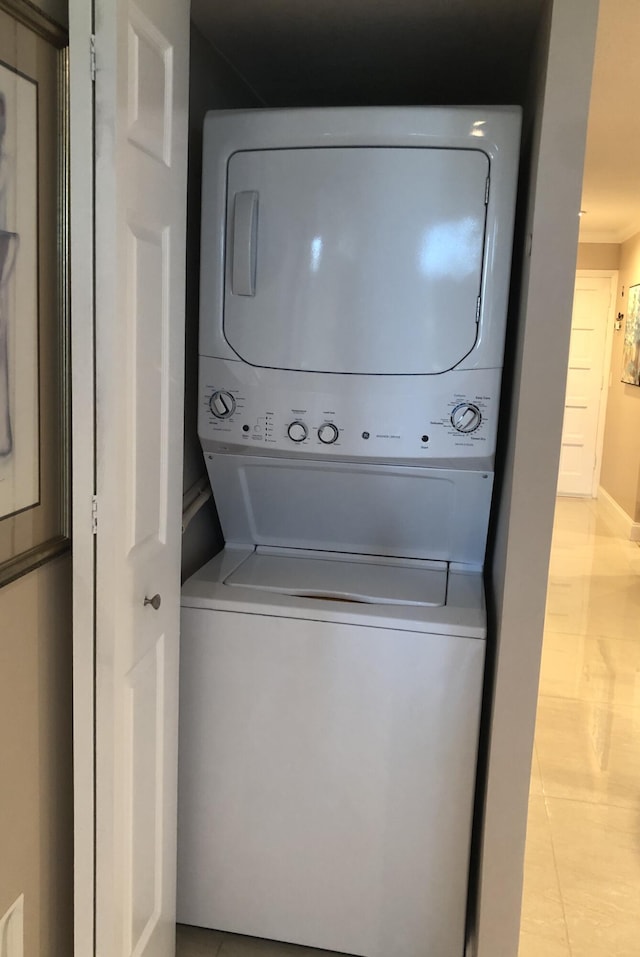 4822 Esedra Ct Unit 101, Lake Worth, FL 33467 - washroom with estacked washer and dryer, light tile patterned floors, and baseboards