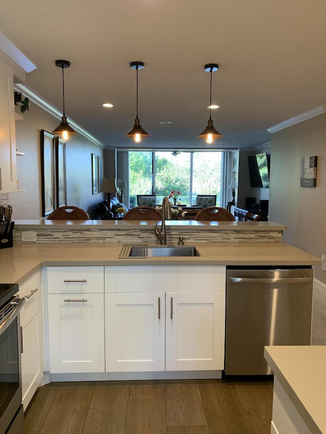 kitchen featuring open floor plan, appliances with stainless steel finishes, a sink, and crown molding