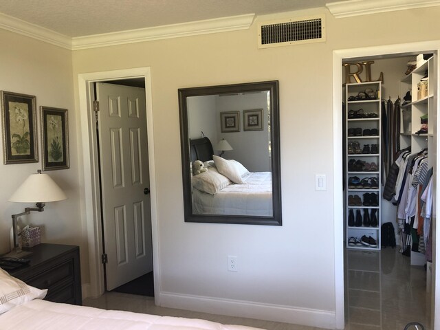 tiled living area with baseboards, a textured ceiling, visible vents, and crown molding