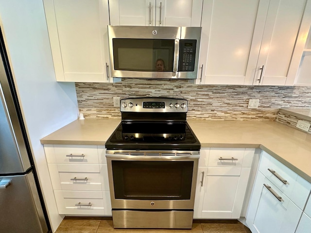 4822 Esedra Ct Unit 101, Lake Worth, FL 33467 - kitchen with appliances with stainless steel finishes, light countertops, white cabinets, and tasteful backsplash