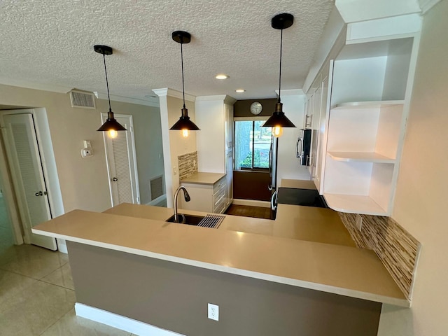 4822 Esedra Ct Unit 101, Lake Worth, FL 33467 - kitchen with open shelves, white cabinetry, a peninsula, a textured ceiling, and a sink