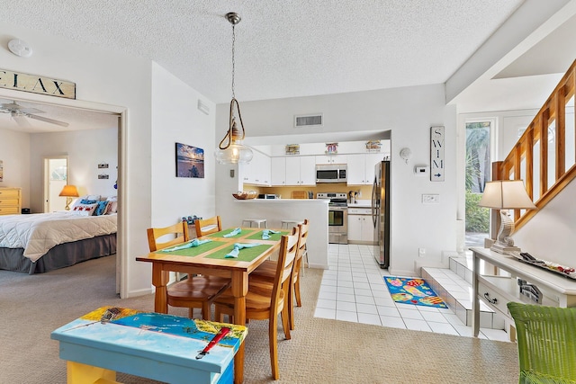 dining space with light colored carpet, visible vents, stairway, and a textured ceiling