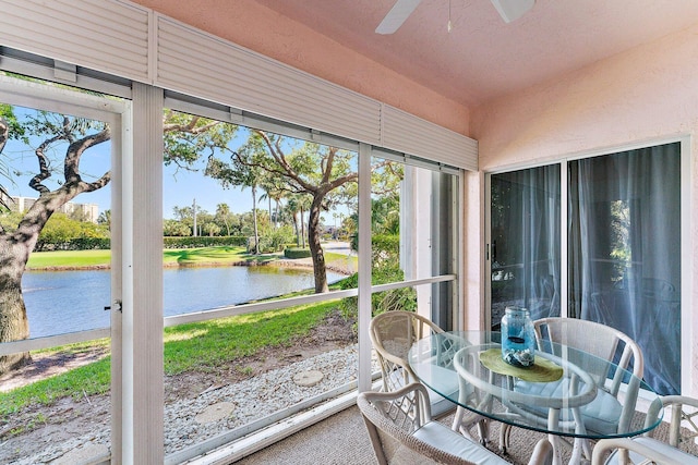 sunroom featuring a water view, plenty of natural light, and ceiling fan