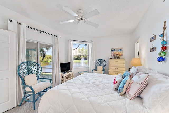 bedroom featuring a textured ceiling, access to outside, and ceiling fan