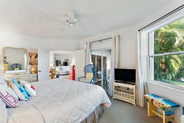 carpeted bedroom with ceiling fan and a textured ceiling