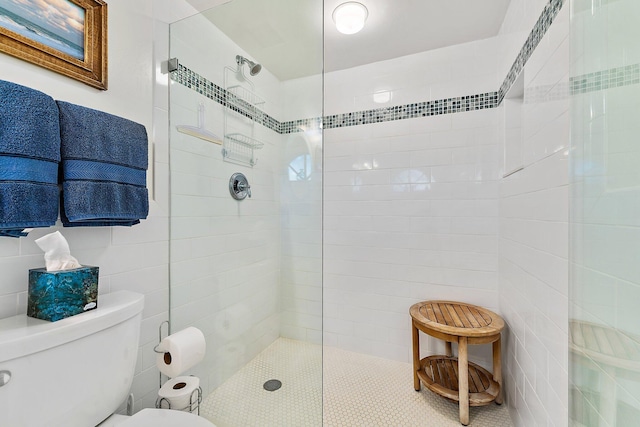 bathroom with toilet, walk in shower, and tile walls