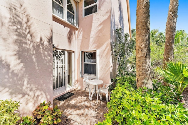 doorway to property featuring stucco siding